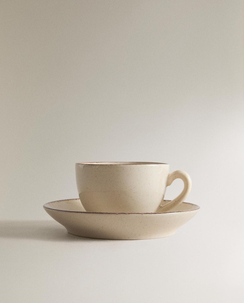 STONEWARE TEACUP AND SAUCER WITH ANTIQUE FINISH RIM