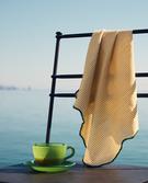 TASSE À CAFÉ, CHAISE EN FER FORGÉ ET SERVIETTE DE TABLE