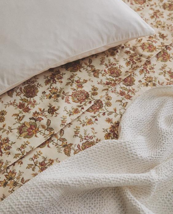 OVERLAGEN I SATIN MED BLOMSTER