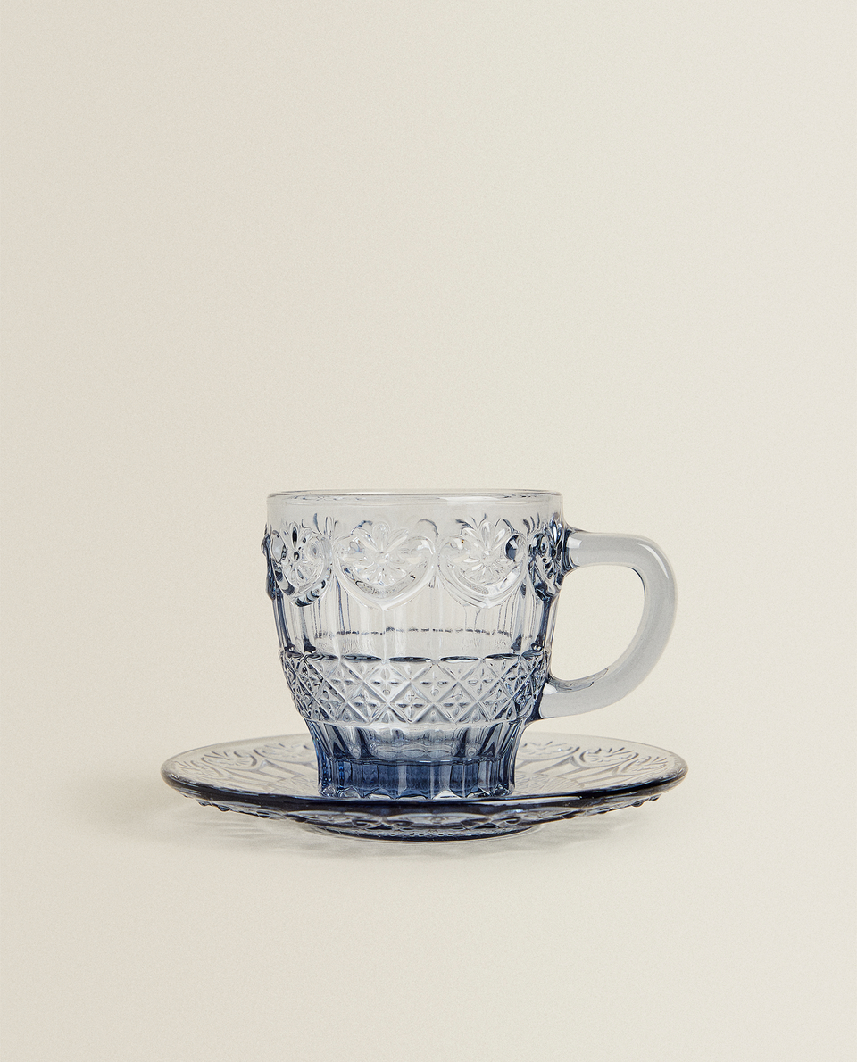 فنجان قهوة مع طبق زجاجي أزرق بتصميم بارز