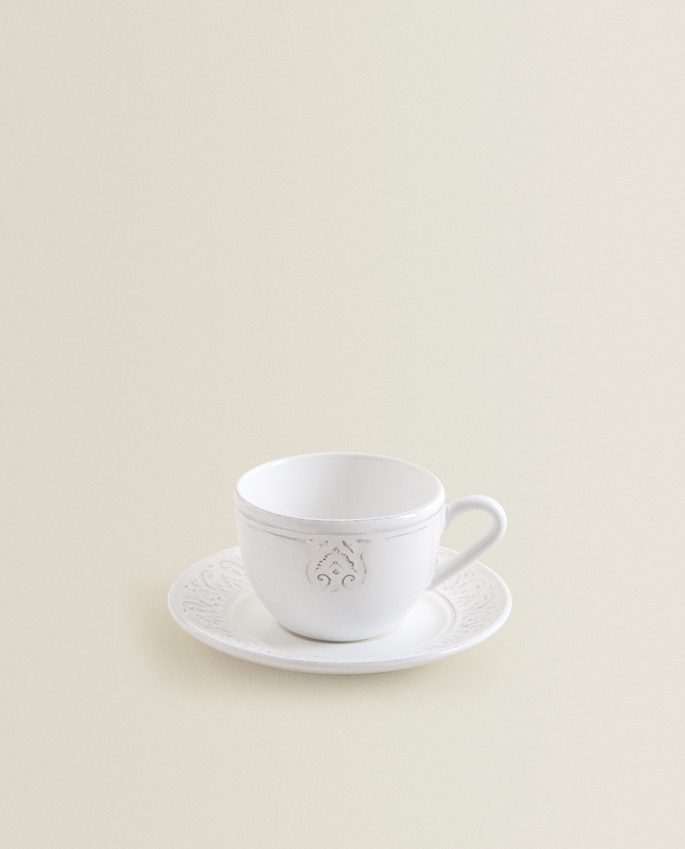 RAISED-DESIGN EARTHENWARE CUP AND SAUCER