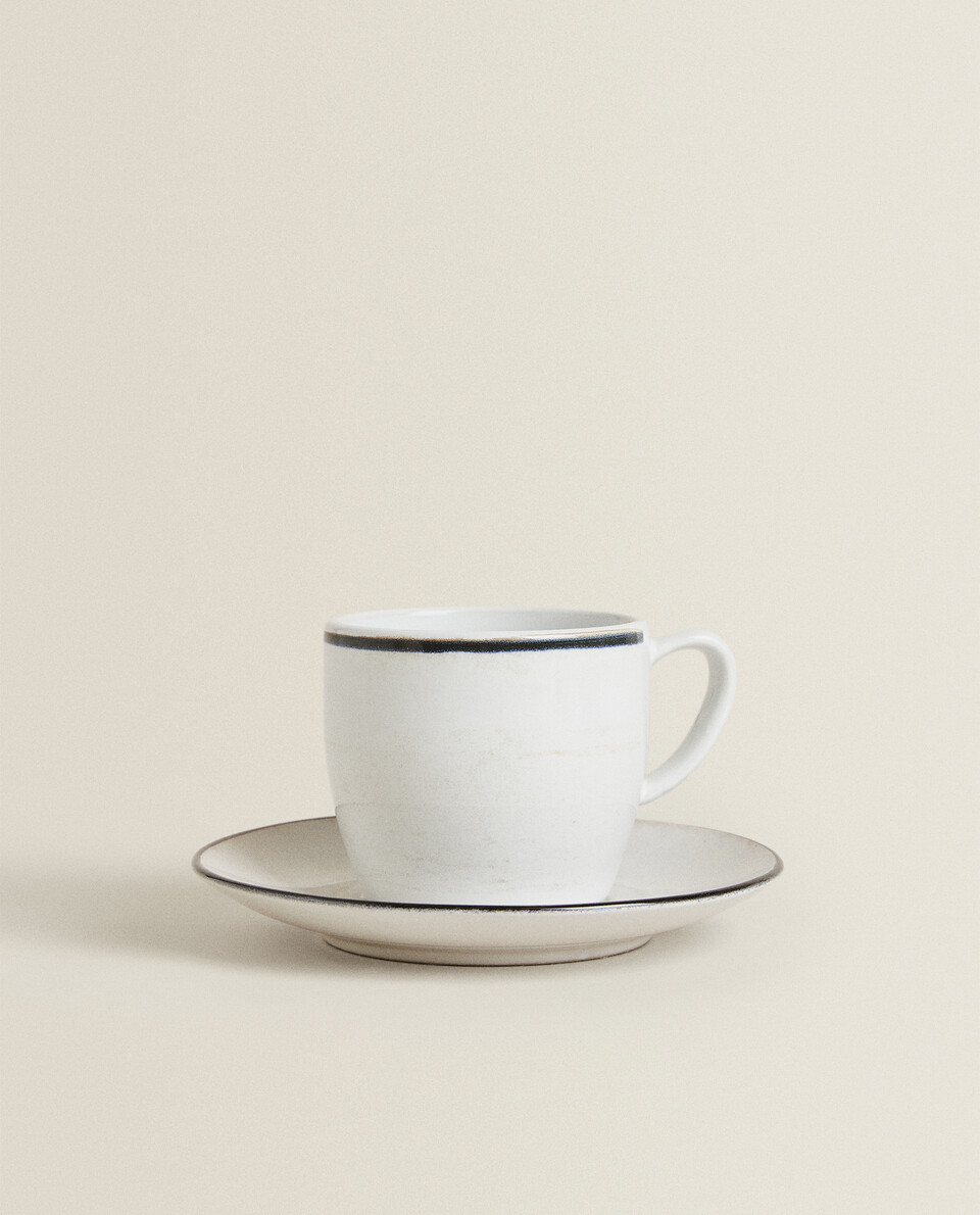 STONEWARE TEACUP AND SAUCER WITH BLACK RIM