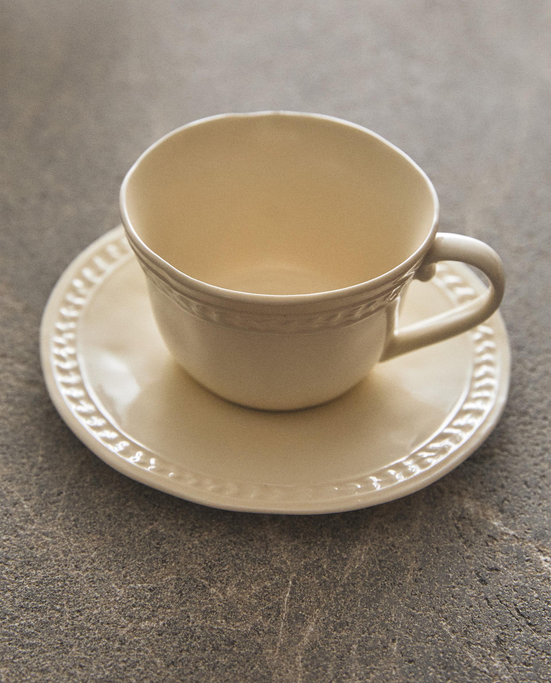 RAISED STONEWARE TEACUP AND SAUCER RAISED STONEWARE TEACUP AND SAUCER
