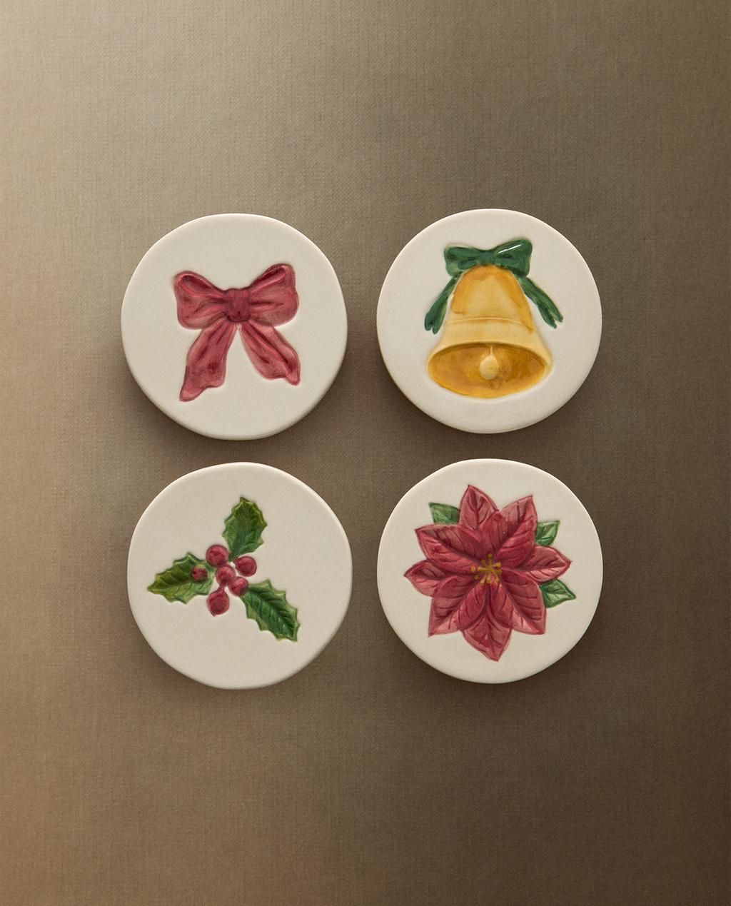 Set štirih božičnih podstavkov z motivi rdeče pentlje, zvonca, bodike in božične zvezde.