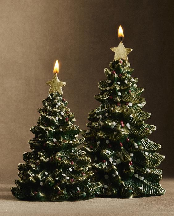 Dve zeleni sveči v obliki božičnega drevesa z zasneženim učinkom in zlatimi zvezdami na vrhu.