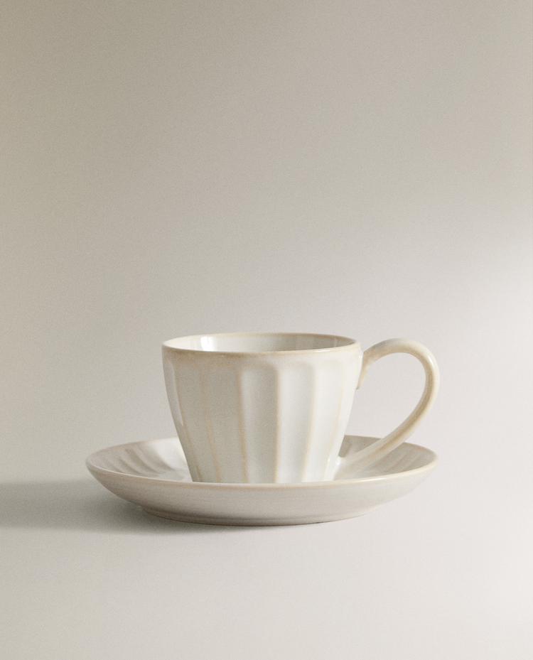 STONEWARE TEACUP AND SAUCER WITH RAISED DESIGN