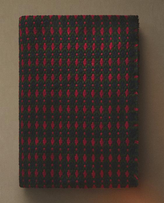 Prednji pogled na zelenu deku s crvenim heklanim uzorkom. Božićni dizajn s pletenom teksturom.