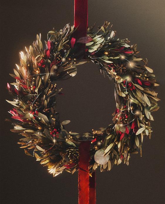 Božični okrasni venec z oljčnimi listi in storži, vgrajenimi lučkami in rdečim trakom za obešanje. Premer 60 cm.