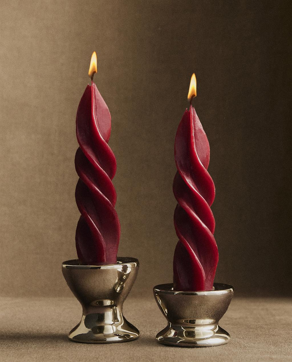 Paket 2 rdečih okrasnih spiralnih sveč, postavljenih v kovinske svečnike.