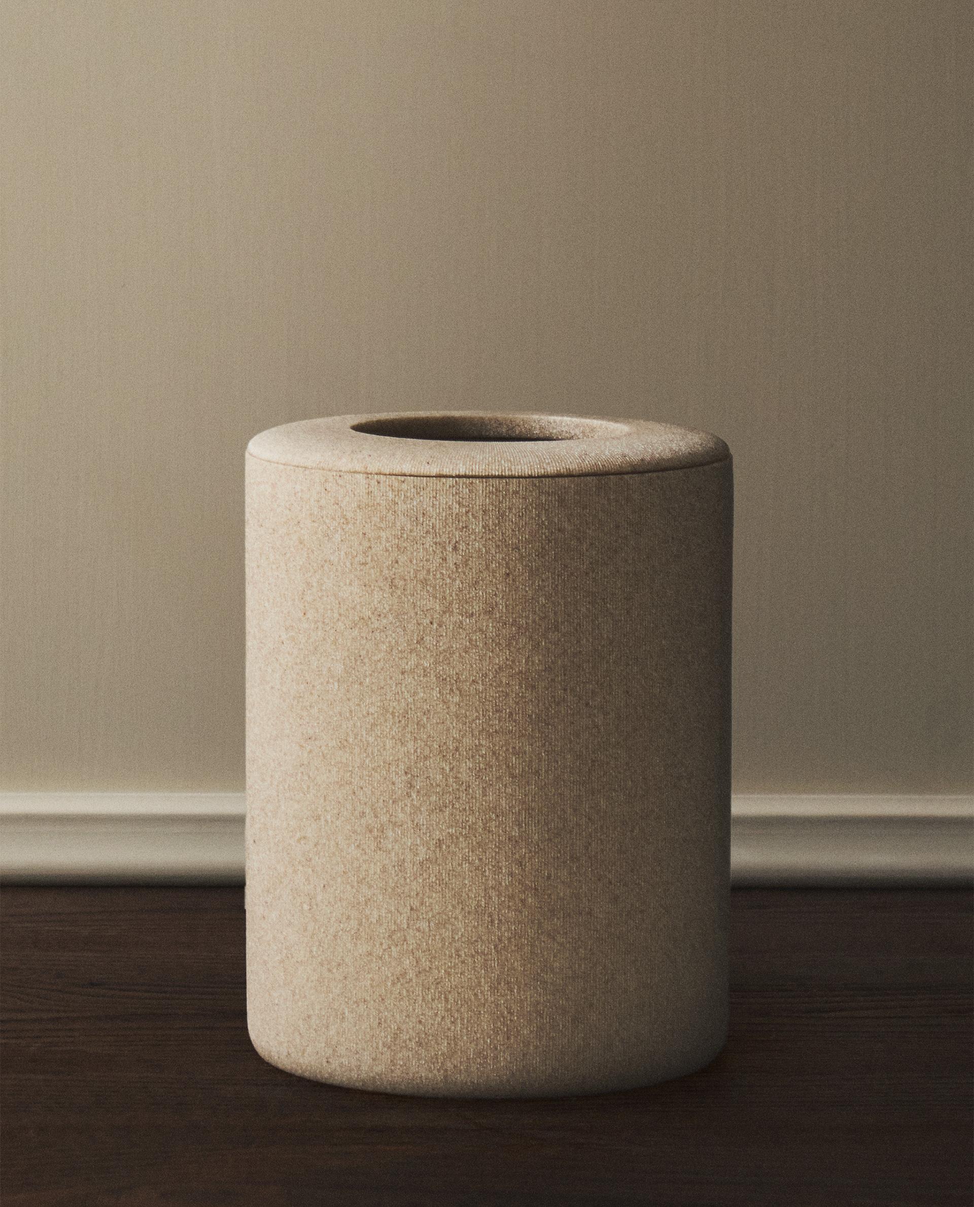 Sprednji pogled na bež cilindrični koš za smeti s preprostim dizajnom za kopalnico.