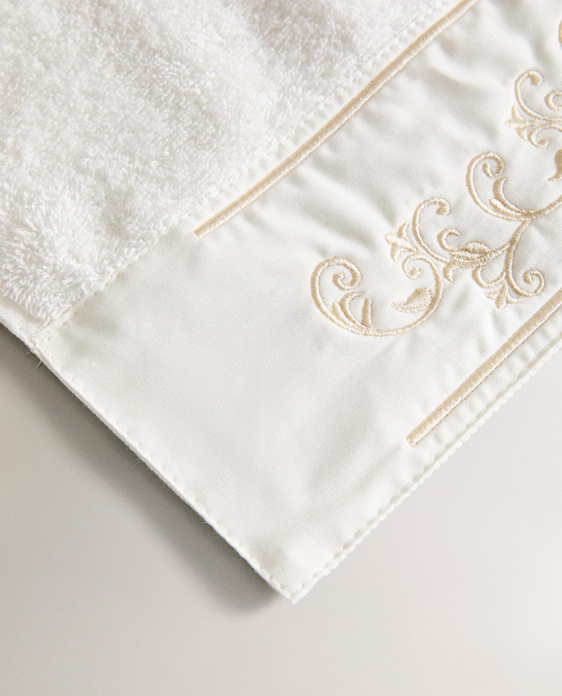 TOWEL WITH EMBROIDERED BAND APPLIQUÉ