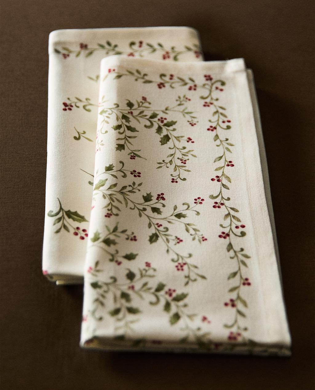 Paket dveh kuhinjskih krp z vzorcem listov in rdečih jagod na belem ozadju.