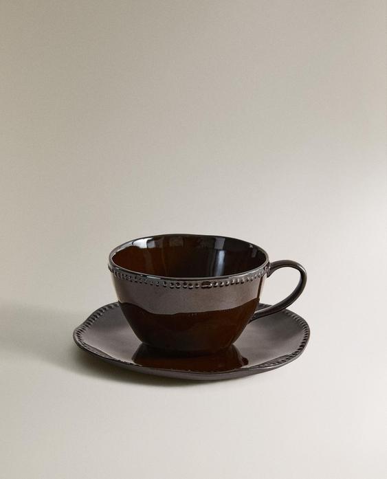 STONEWARE COFFEE CUP AND SAUCER WITH RAISED DESIGN